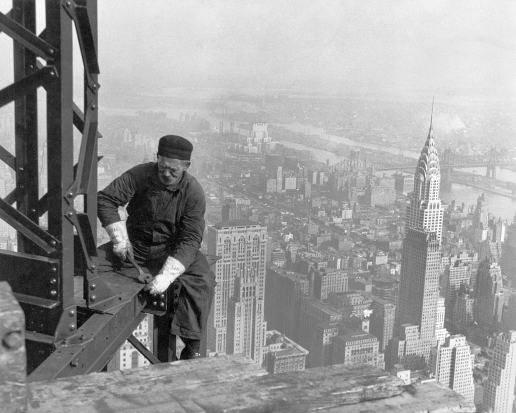 A worker bolts beams during construction; the Chrysler Building can be seen in the background. (Wikipedia)